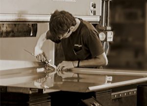 A man cutting some type of metal with scissors.