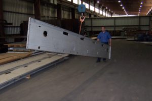 A man holding onto a large metal beam.