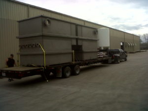 A truck is pulling a large trailer with a tank.