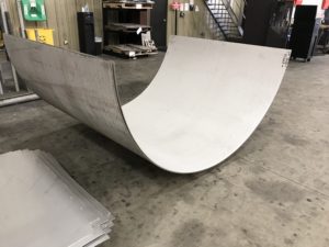 A skateboard ramp is being built in the warehouse.